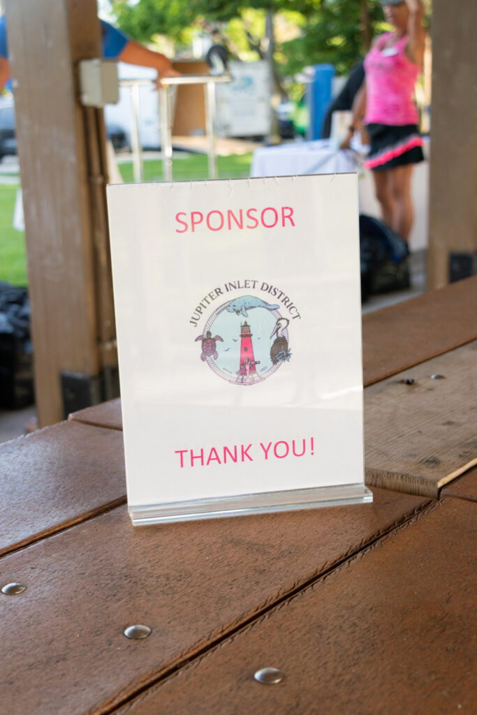 Beach cleanup sponsor display thanking Jupiter Inlet District.