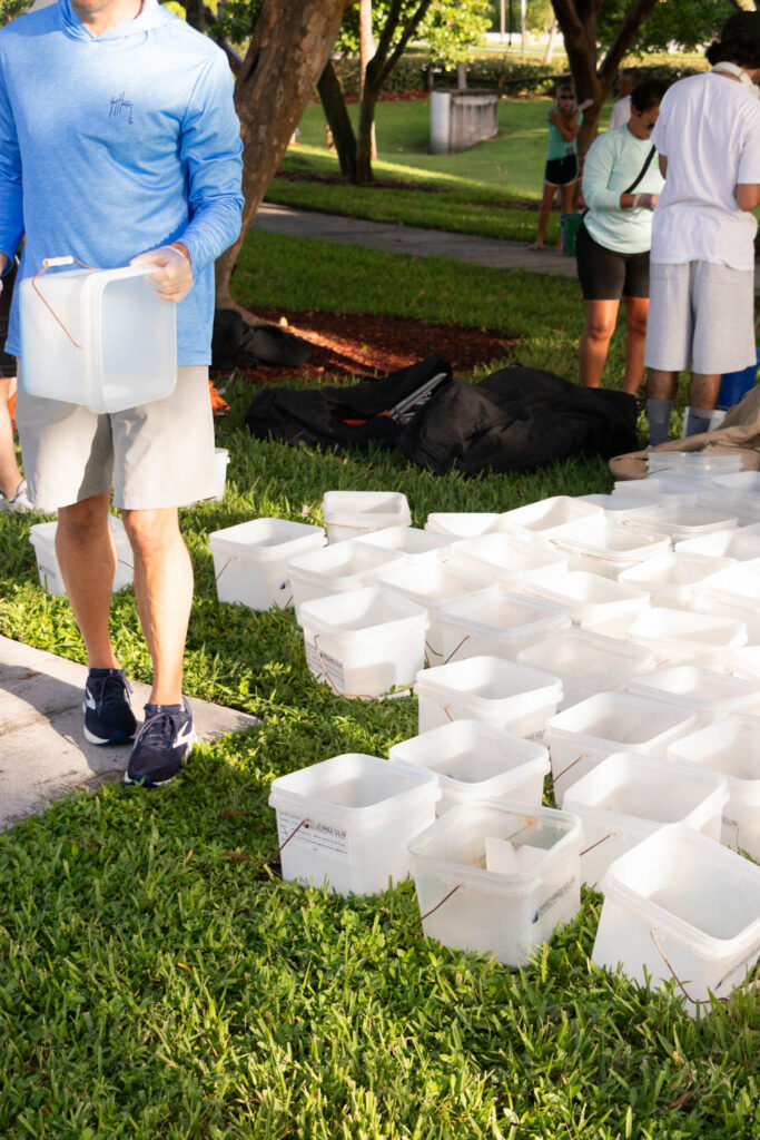 Stacks of white cleanup buckets lined up on the grass before the event.