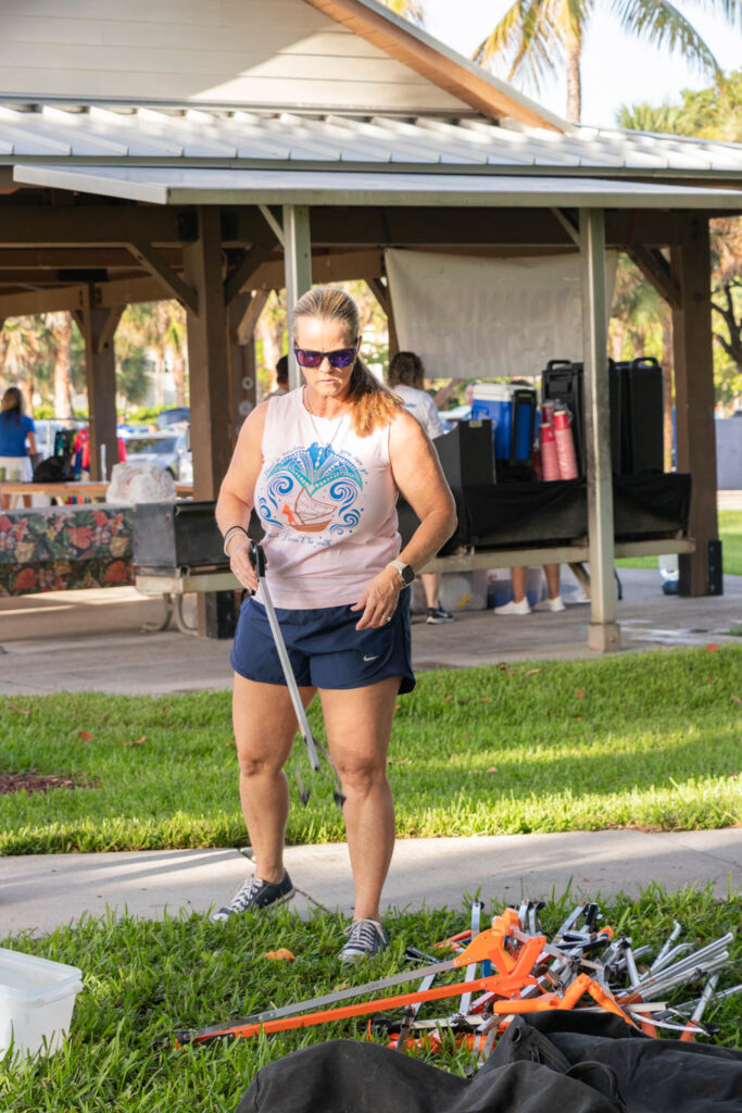 Volunteer standing in the park near the beach cleanup pavilion.