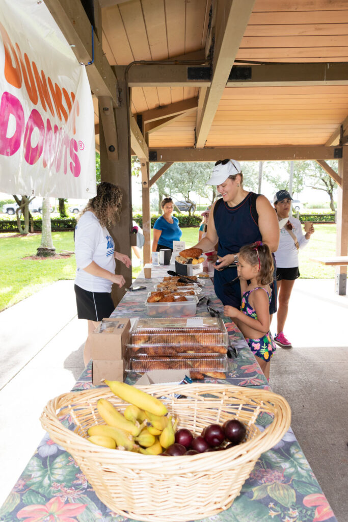 Volunteer collecting refreshments on a table under the pavilion.