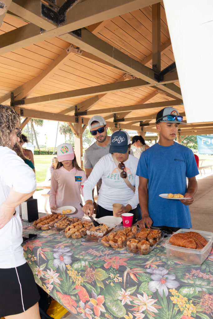 Volunteer collecting refreshments on a table under the pavilion.