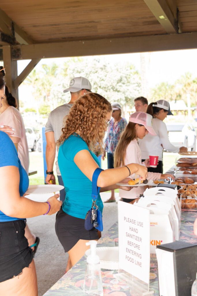 Volunteer collecting refreshments on a table under the pavilion.