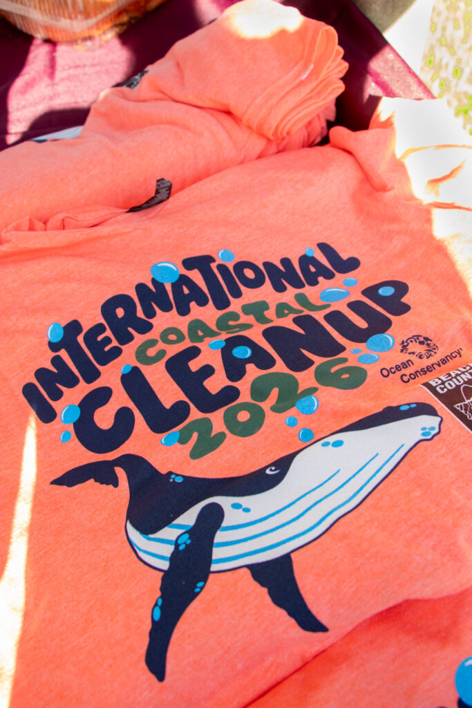 Photo of the orange International Coastal Cleanup 2026 T-shirt graphic.