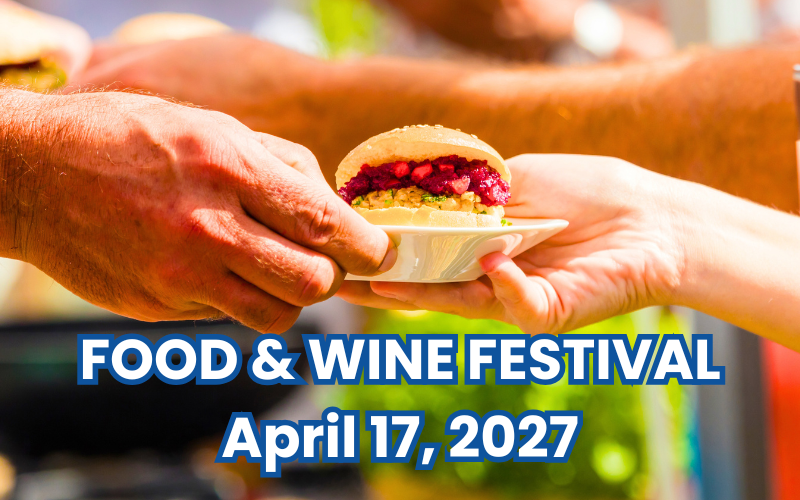 sandwich on a plate being handed to someone linking to a webpage with details of the food and wine festival