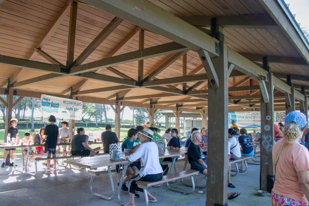 Friends of Jupiter Beach volunteers sitting on benches under the pavilion.