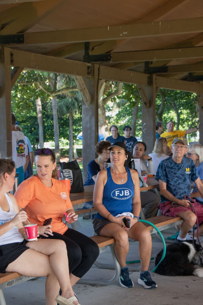 Friends of Jupiter Beach volunteers sitting on benches under the pavilion.