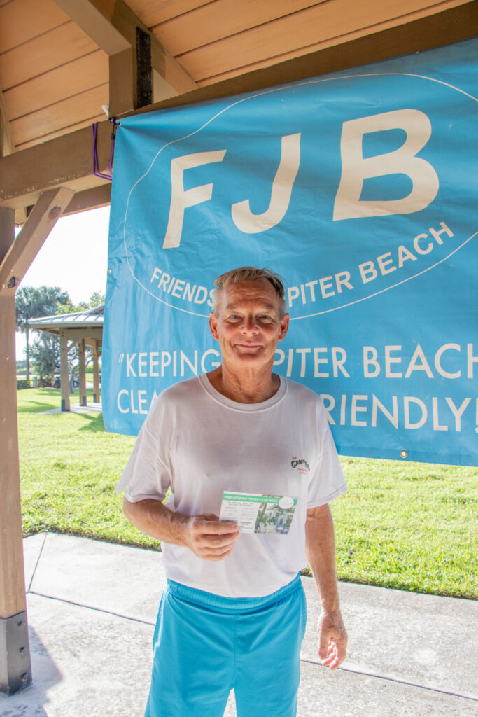 Friends of Jupiter Beach raffle winner smiling with a gift certificate.