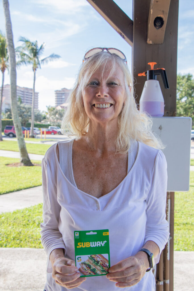 Friends of Jupiter Beach raffle winner smiling with a gift certificate.