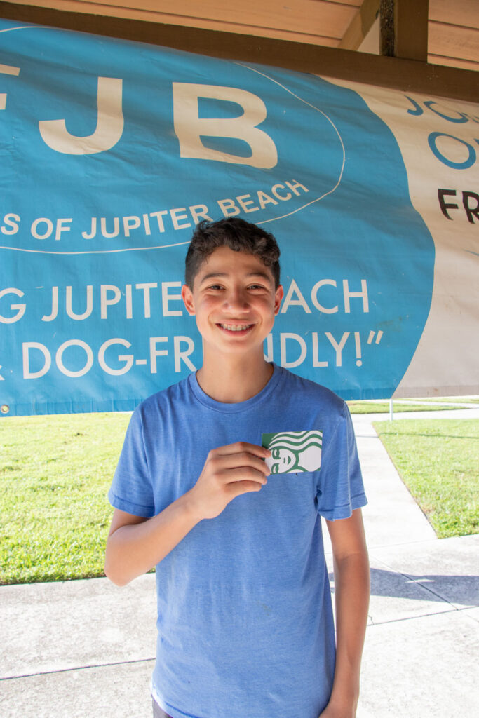 Friends of Jupiter Beach raffle winner smiling with a gift certificate.