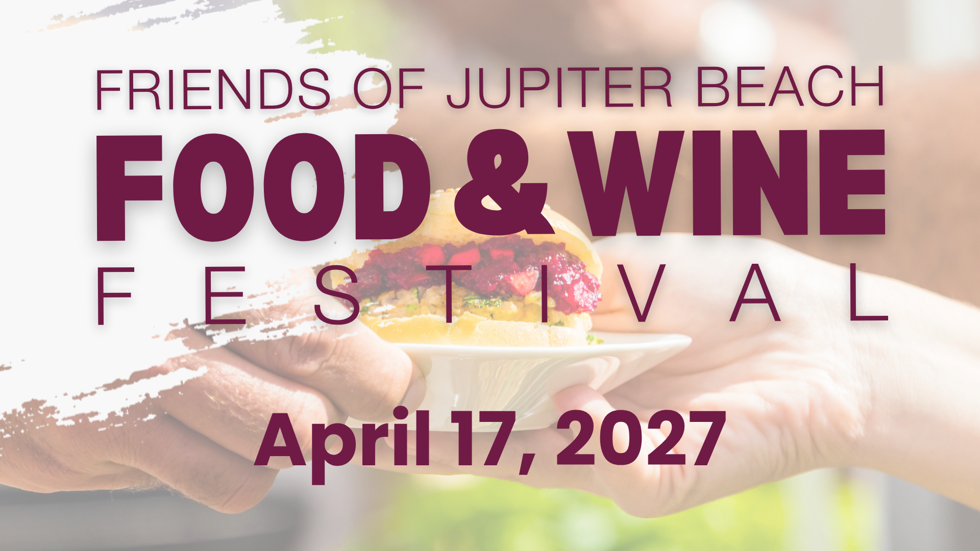 sandwich on a plate being handed to someone linking to a webpage with details of the food and wine festival